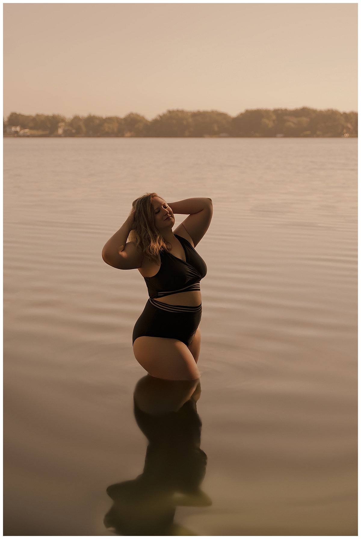 Woman stands in the water wearing a black bathing suit for Emma Christine Photography