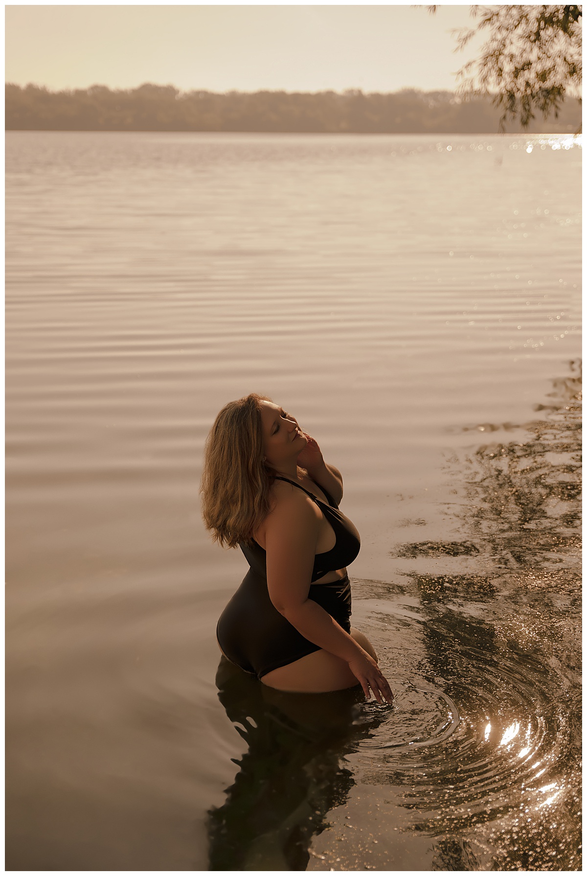 Woman stands in the water wearing a bathing suit during a Lakeside Boudoir session