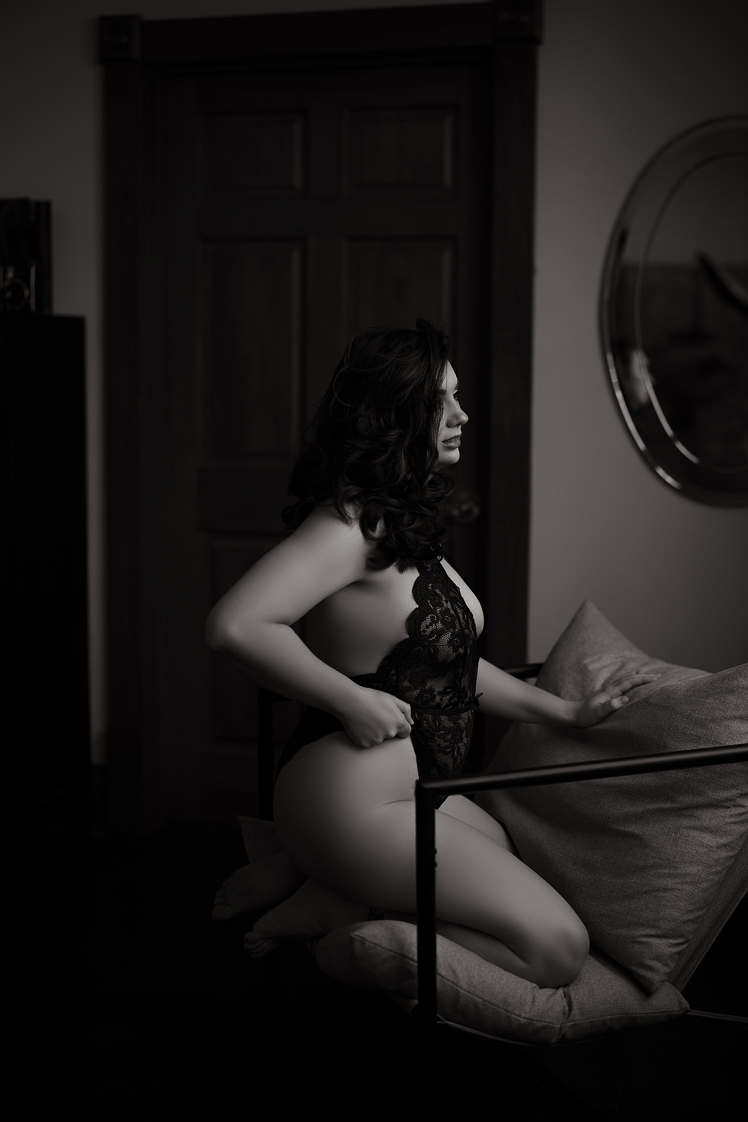 brunette kneels on chair in lace lingerie by Sioux Falls boudoir photographer 