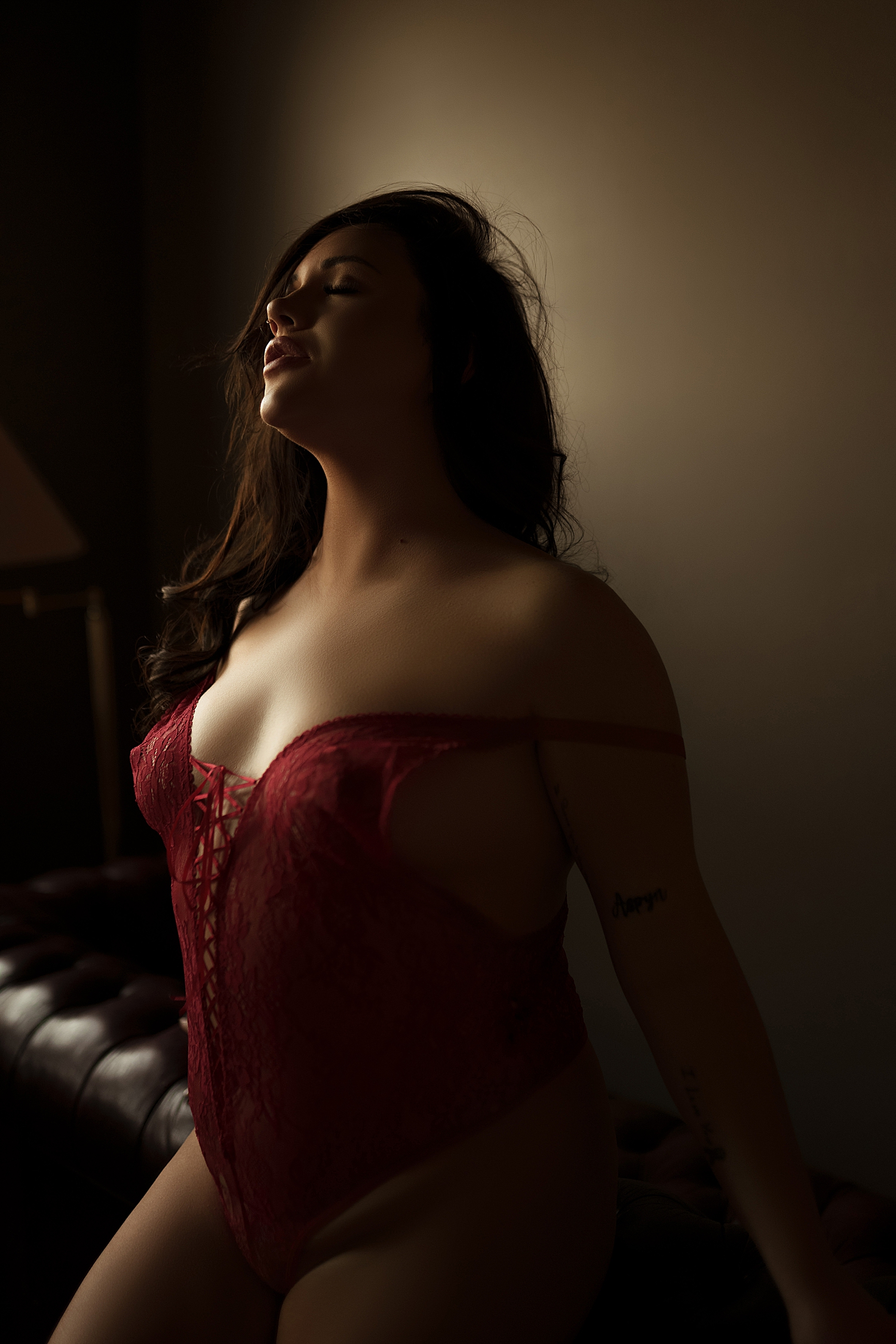 woman in red lingerie sits on couch with Custom styling 