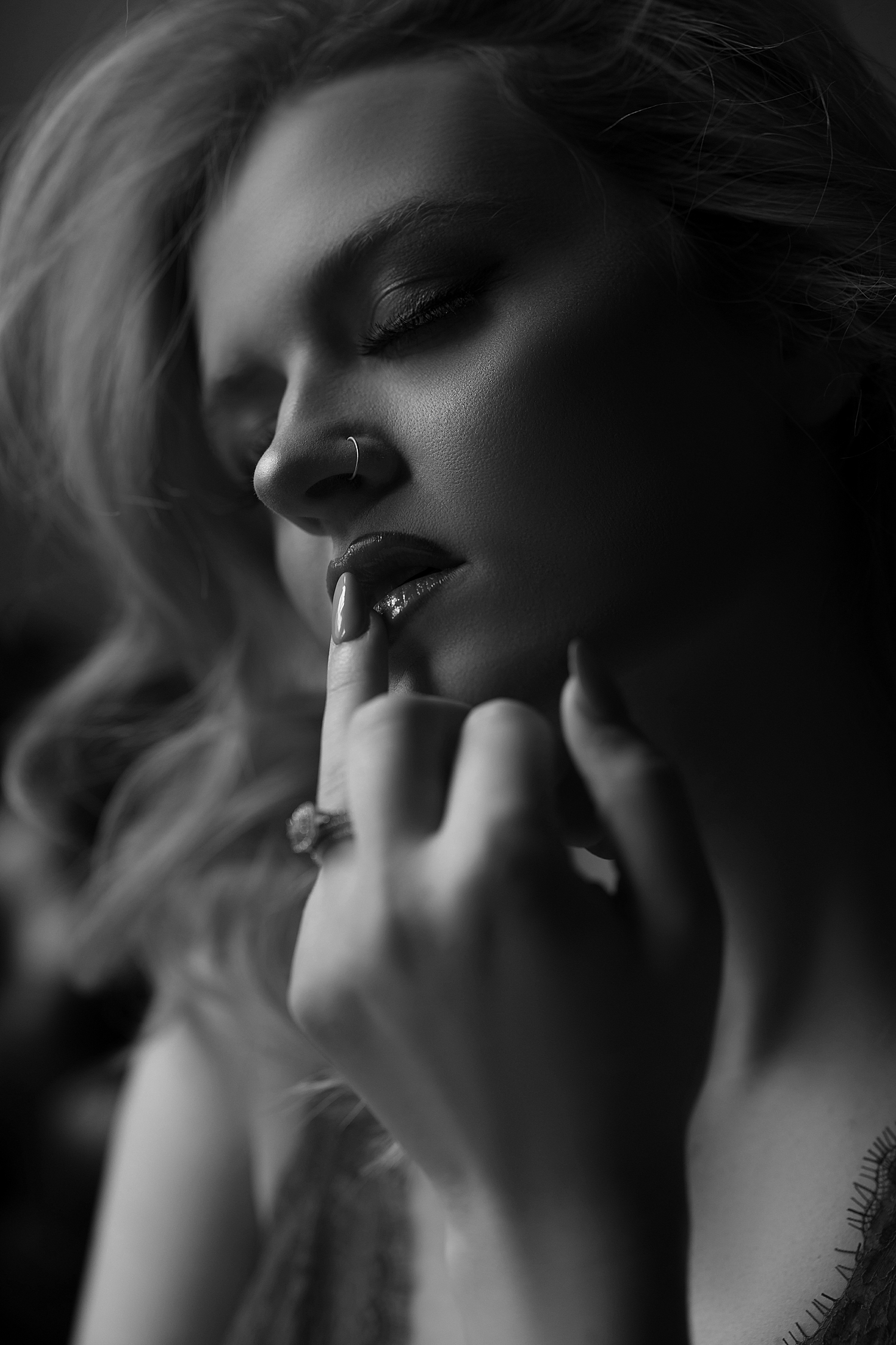 model touches her lips sensually by Sioux Falls boudoir photographer