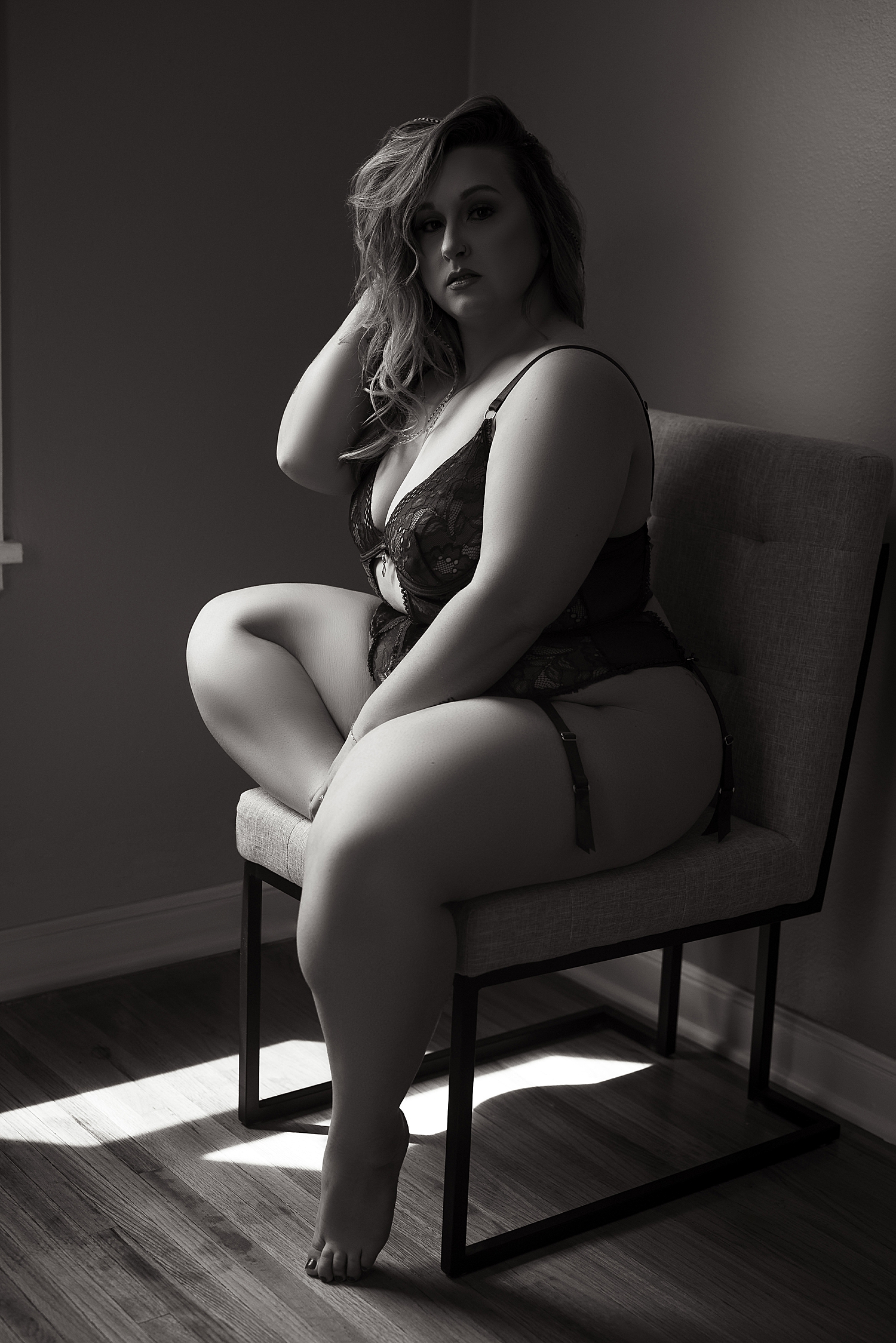 busy mama sits in chair in lingerie near window