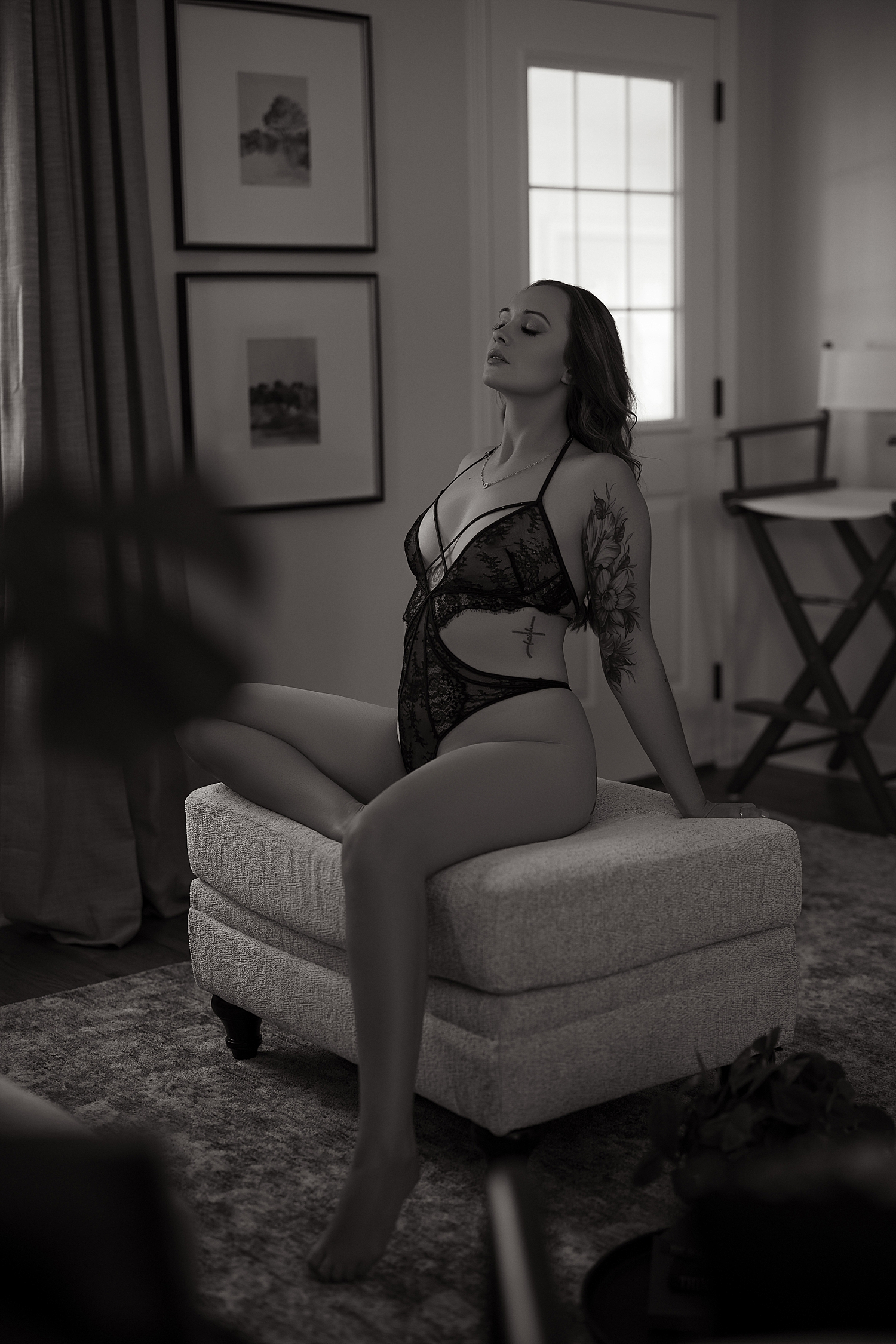 model sits on Ottoman in studio house by Sioux Falls Boudoir Photographer